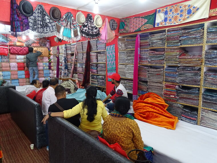 A sari shop near Shimla, its shelves stacked to the ceiling, customers being served at the counter